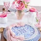 Tabletop setting with blue and white pattern dishes with pink florals and gold hardware.